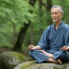 「亀仙人はなぜ長生き」を連想させる、穏やかな自然の中で瞑想する長寿の日本人男性。精神的な調和と健康の象徴。