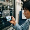 スマートフォンでショートドラマを視聴する日本人男性。「最弱無敗の転校生」はどこで見れるか探している視聴者。